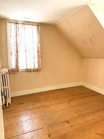 a view of a room with wooden floor and windows