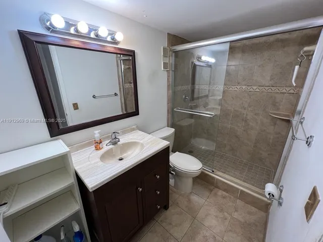 a bathroom with a sink vanity mirror and toilet