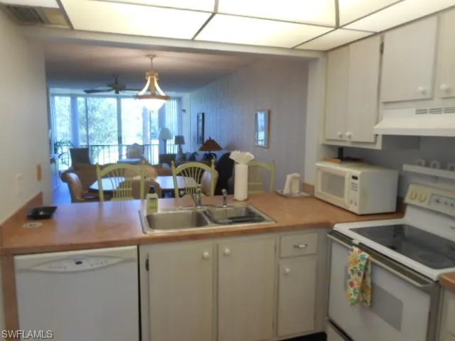 a kitchen with sink a stove and cabinets