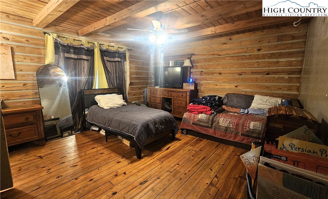 480 Schoolhouse Ridge Boone, NC 28607 - Photo 19 of 47 a bedroom with a bed and wooden floor