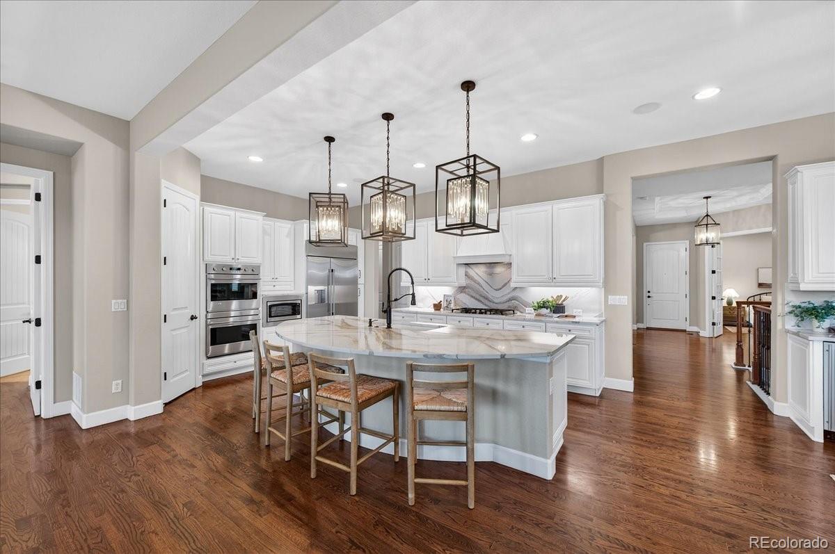 10693 Featherwalk Way Highlands Ranch, CO 80126 - Photo 13 of 50 a view of a dining room and livingroom with furniture wooden floor a chandelier