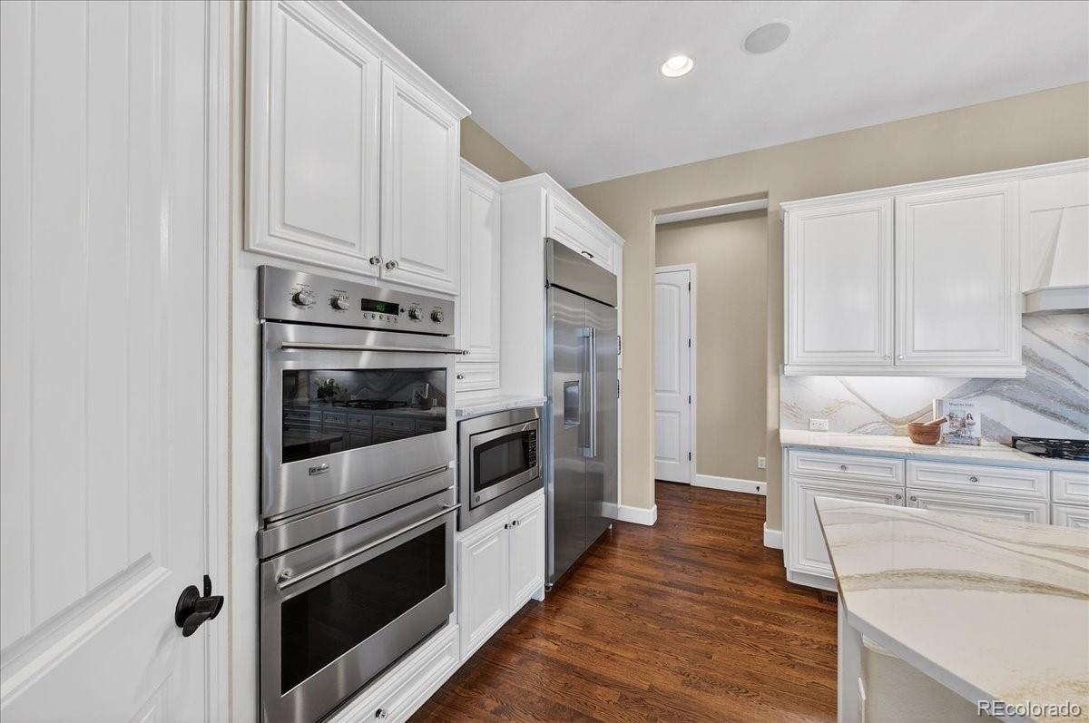 10693 Featherwalk Way Highlands Ranch, CO 80126 - Photo 14 of 50 a kitchen with granite countertop white cabinets and stainless steel appliances