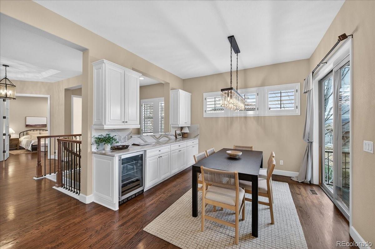 10693 Featherwalk Way Highlands Ranch, CO 80126 - Photo 16 of 50 a kitchen that has a table chairs in it and wooden floors