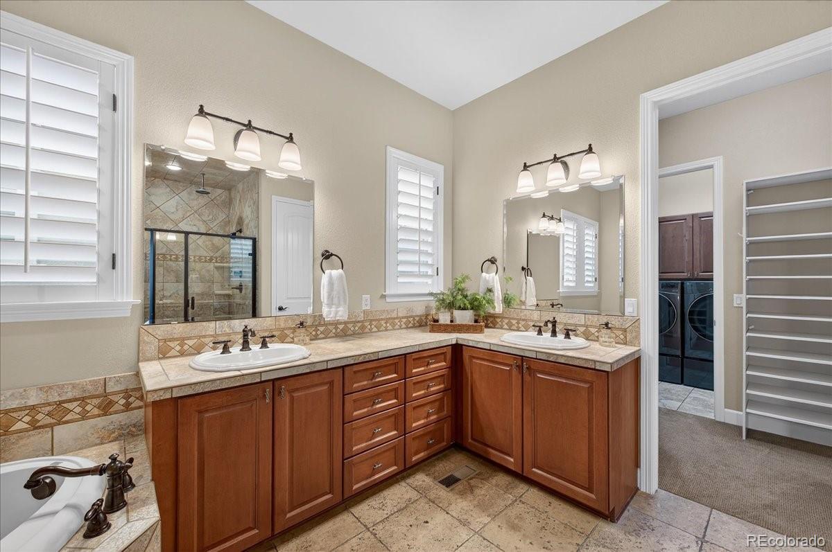 10693 Featherwalk Way Highlands Ranch, CO 80126 - Photo 25 of 50 a bathroom with a sink mirror and a bath tub