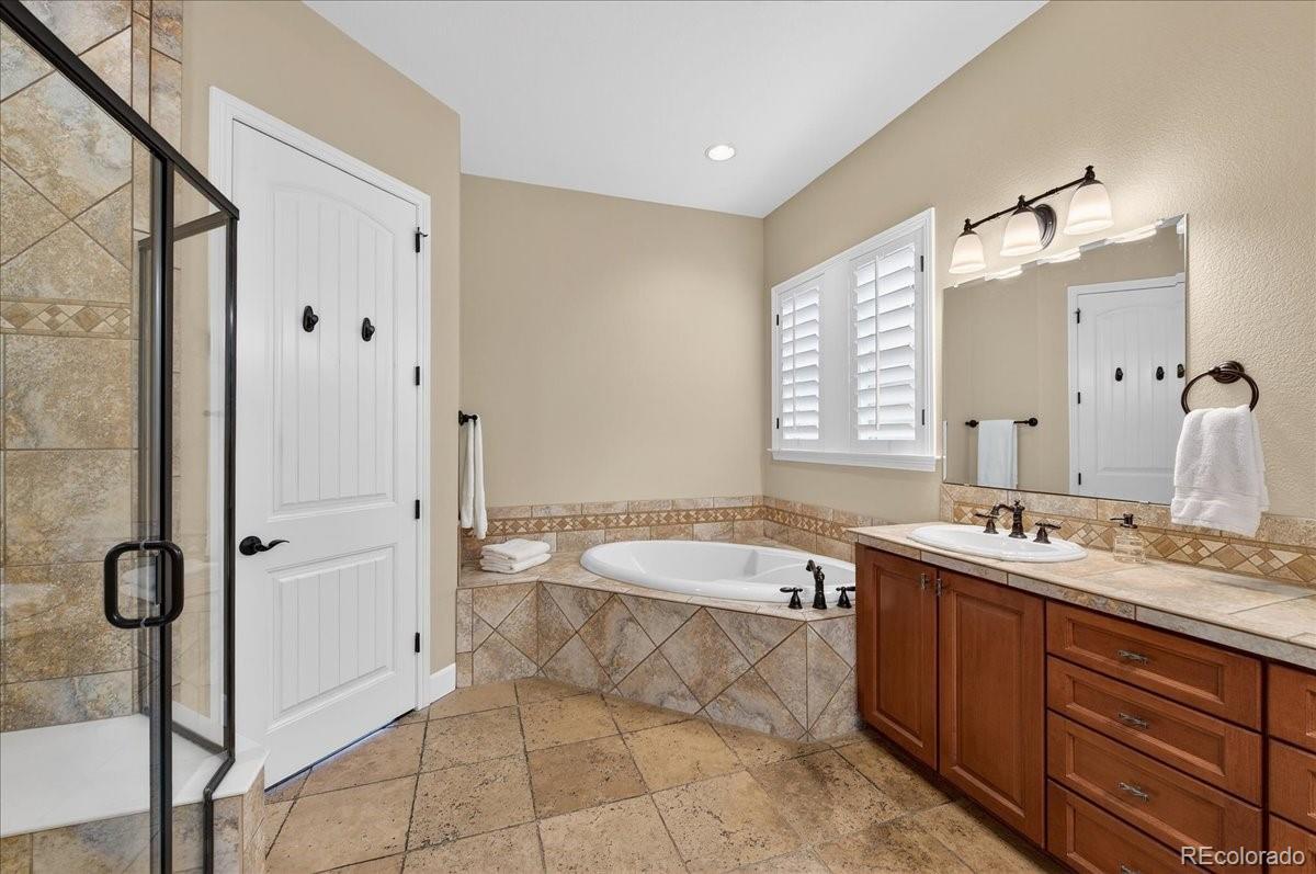 10693 Featherwalk Way Highlands Ranch, CO 80126 - Photo 26 of 50 a spacious bathroom with a tub sink and mirror