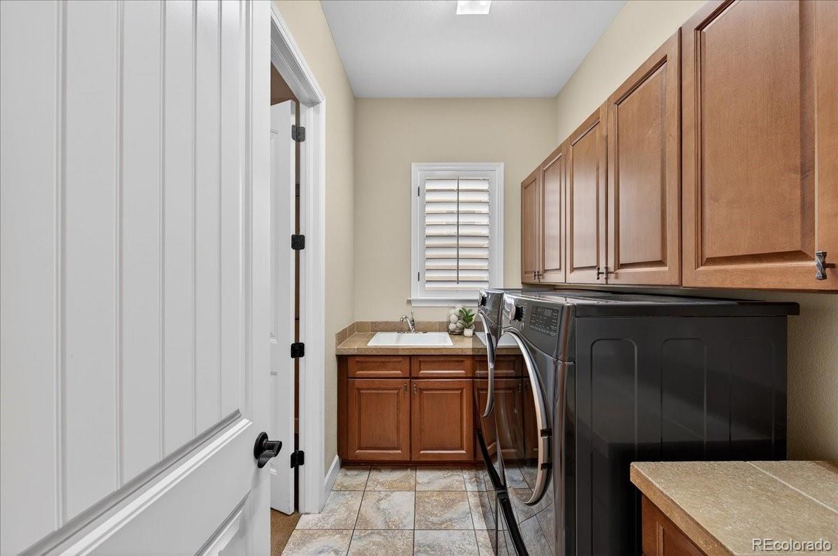10693 Featherwalk Way Highlands Ranch, CO 80126 - Photo 29 of 50 a utility room with a sink a washer and dryer