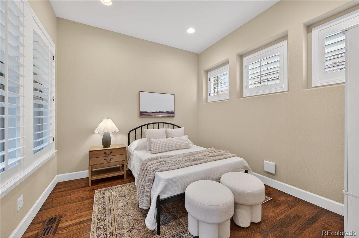 10693 Featherwalk Way Highlands Ranch, CO 80126 - Photo 8 of 50 a bedroom with a bed and wooden floor