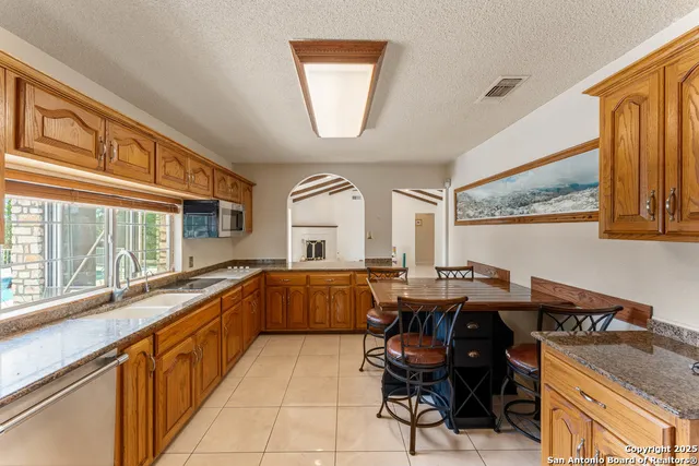 a kitchen with a table chairs sink and cabinets