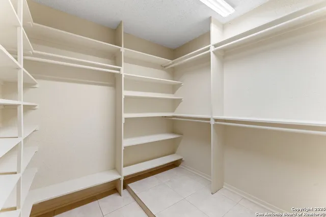 a view of walk in closet with empty racks