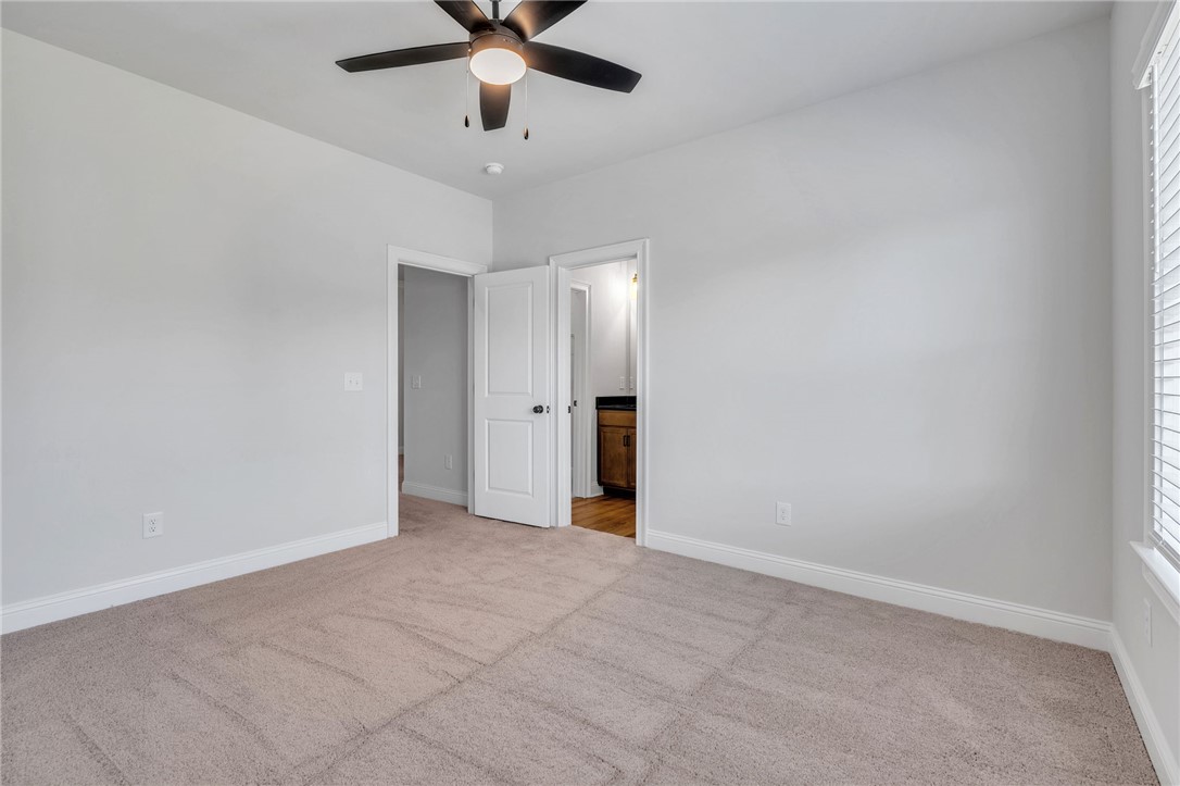 226 Holly Br Road Piedmont, SC 29673 - Photo 30 of 44 A well-lit bedroom features plush carpeting and convenient access to an en-suite bathroom.