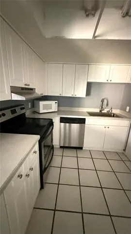 a kitchen with a sink a stove and cabinets
