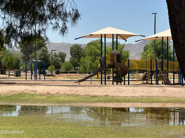 a view of a swimming pool with a table and chairs under an umbrella