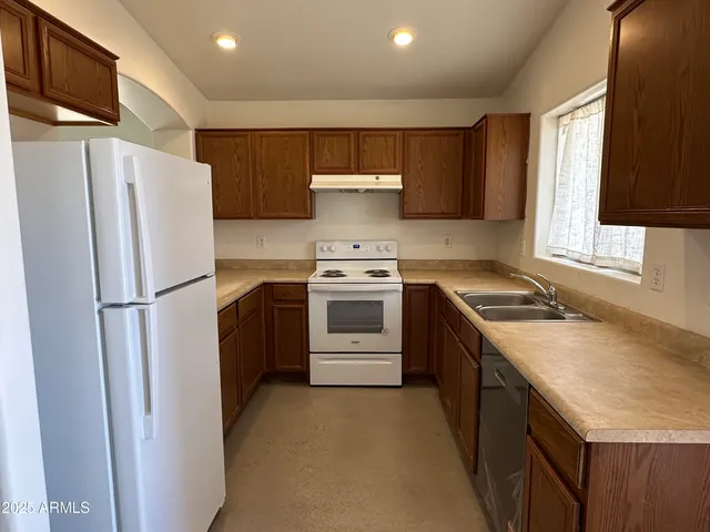 a kitchen with a stove sink and refrigerator