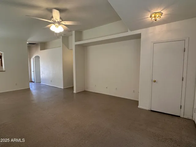 an empty room with fan and entrance