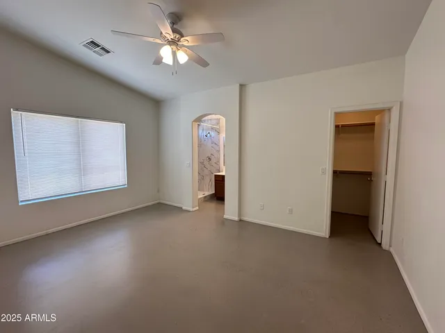 an empty room with a ceiling fan and a window