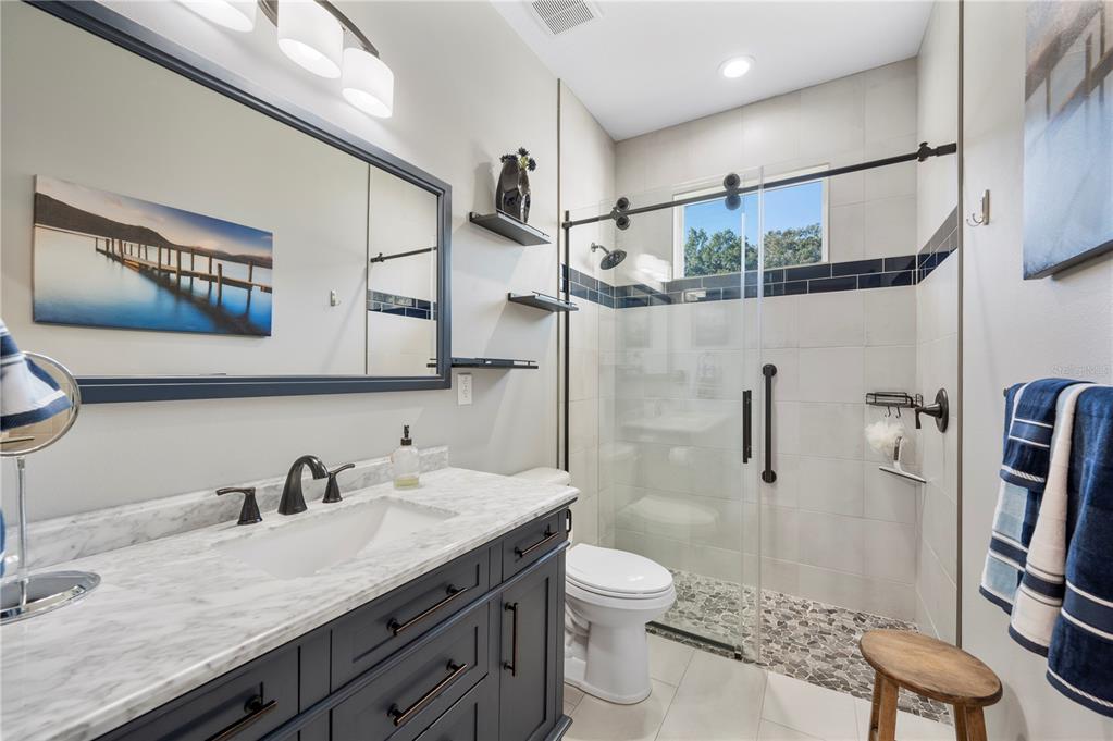 2525 Ranchland Acres Road Lakeland, FL 33809 - Photo 27 of 68 a bathroom with a granite countertop sink a toilet a mirror and shower