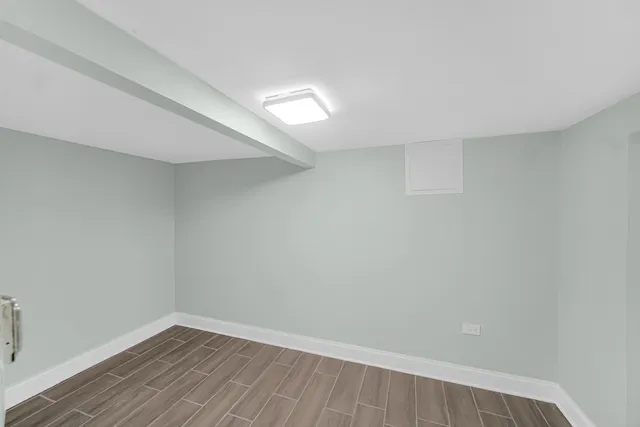 a view of an empty room with wooden floor