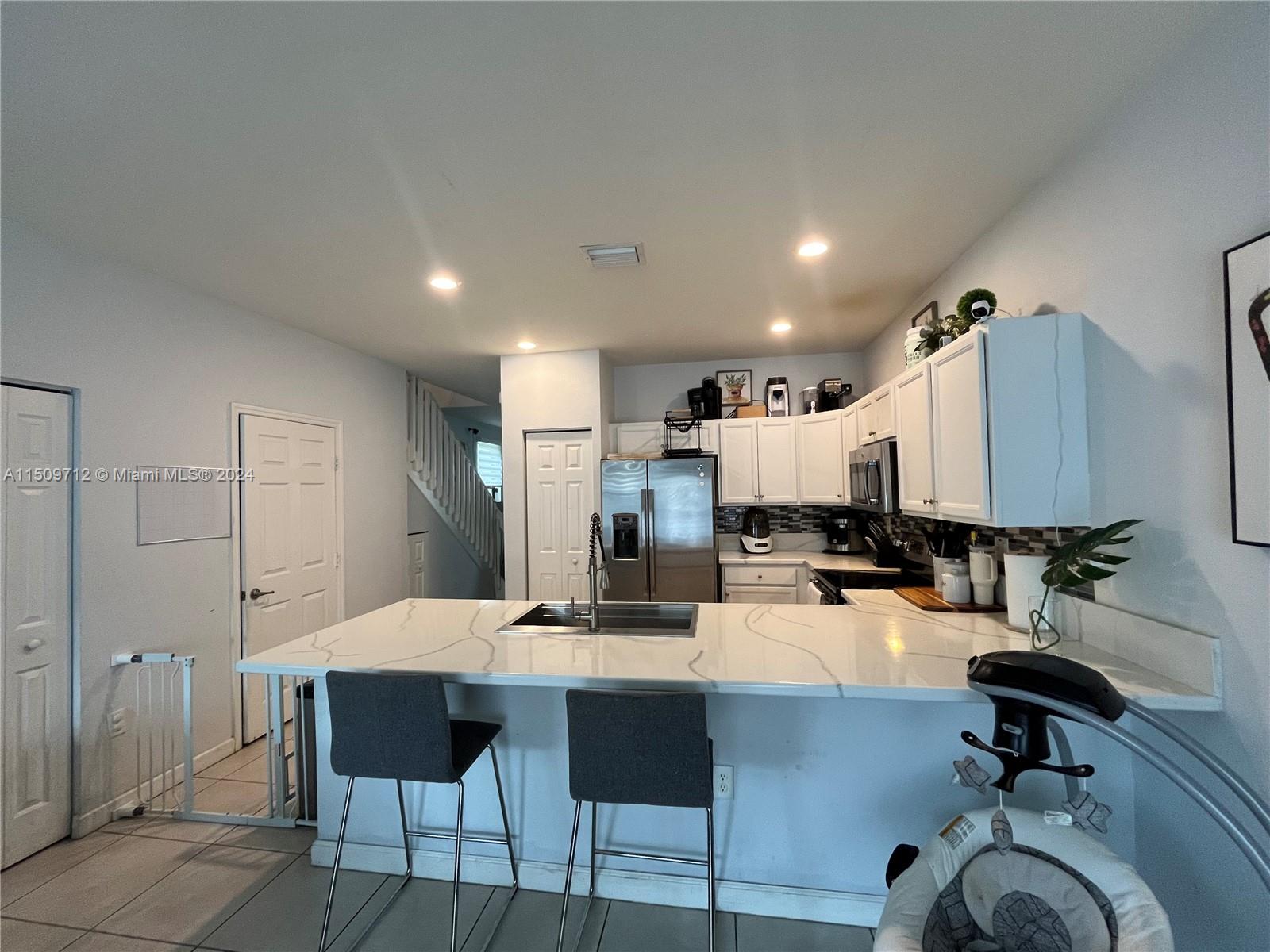 Hialeah Hialeah, FL 33018 - Photo 3 of 23 a kitchen with a dining table chairs stainless steel appliances and cabinets