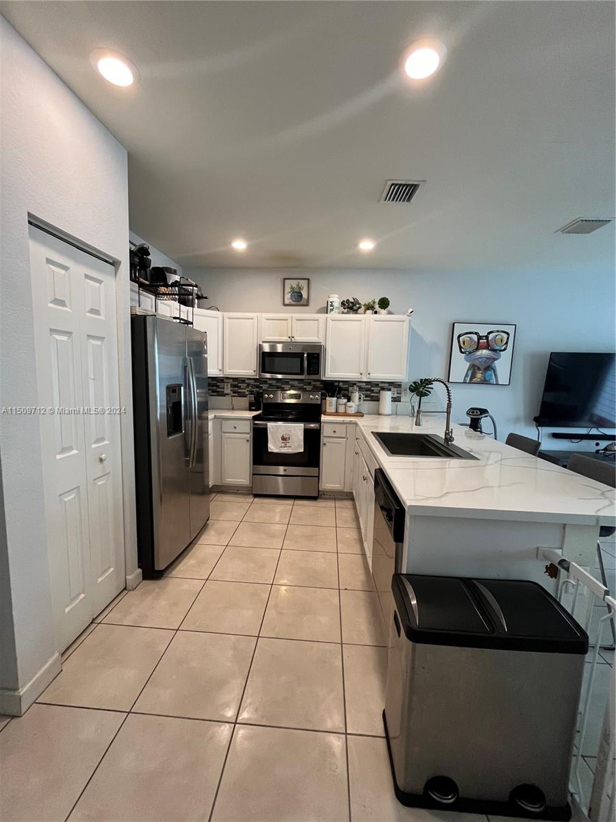 Hialeah Hialeah, FL 33018 - Photo 4 of 23 a kitchen with stainless steel appliances a refrigerator a sink a stove top oven a counter space and cabinets