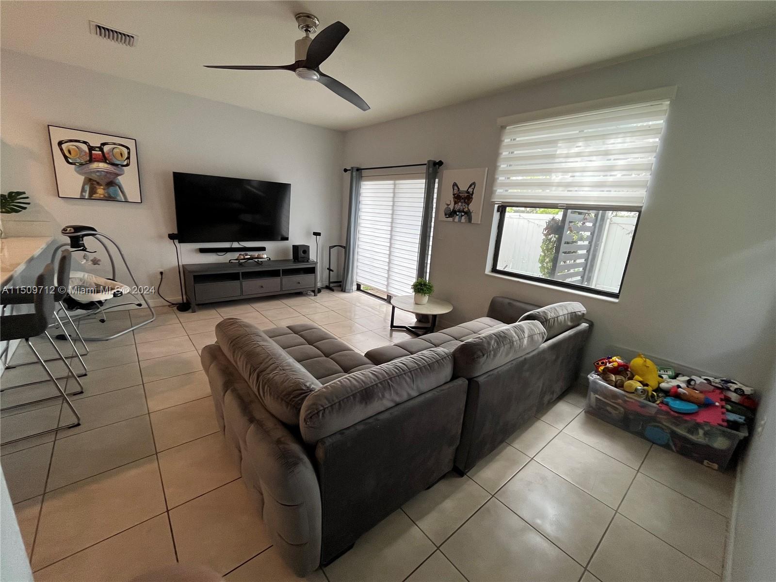 Hialeah Hialeah, FL 33018 - Photo 10 of 23 a living room with furniture a flat screen tv and a window