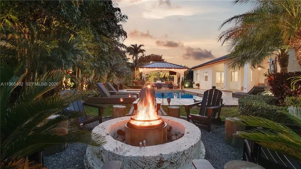 a view of a house with backyard fountain and sitting area