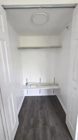 a view of a closet with wooden floor