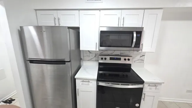 a kitchen with a refrigerator stove and microwave