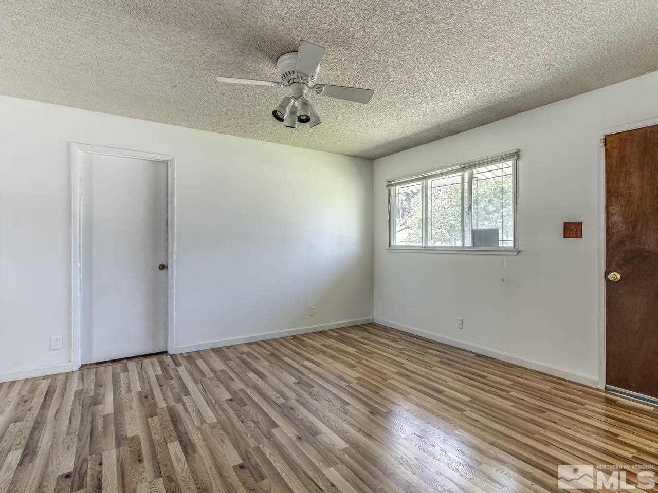 1120 Manhattan Street Reno, NV 89512 - Photo 4 of 23 a view of an empty room with wooden floor and a window