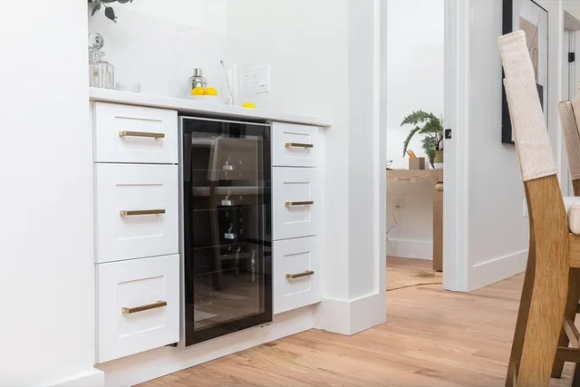 a view of a kitchen with white cabinets and a refrigerator