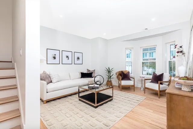 a living room with furniture a wooden floor and potted plant