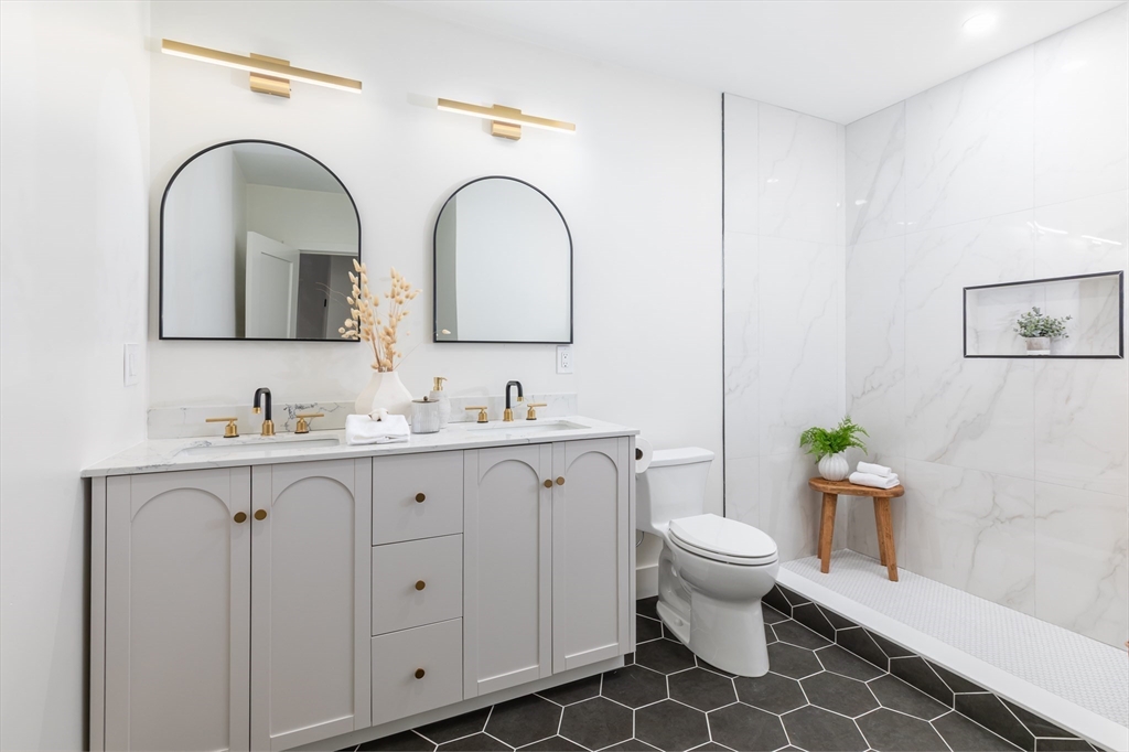 34 Waverly Place, Unit 34 Melrose, MA 02176 - Photo 34 of 39 a bathroom with a granite countertop toilet a sink and a mirror