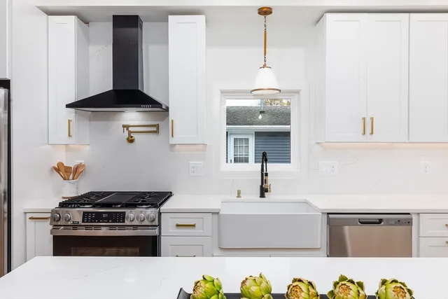 a kitchen with stainless steel appliances a stove a white refrigerator and a stove