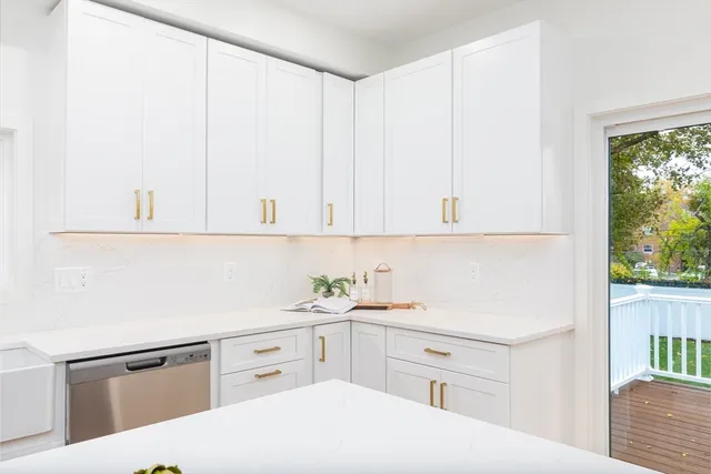 a kitchen with white cabinets and white appliances
