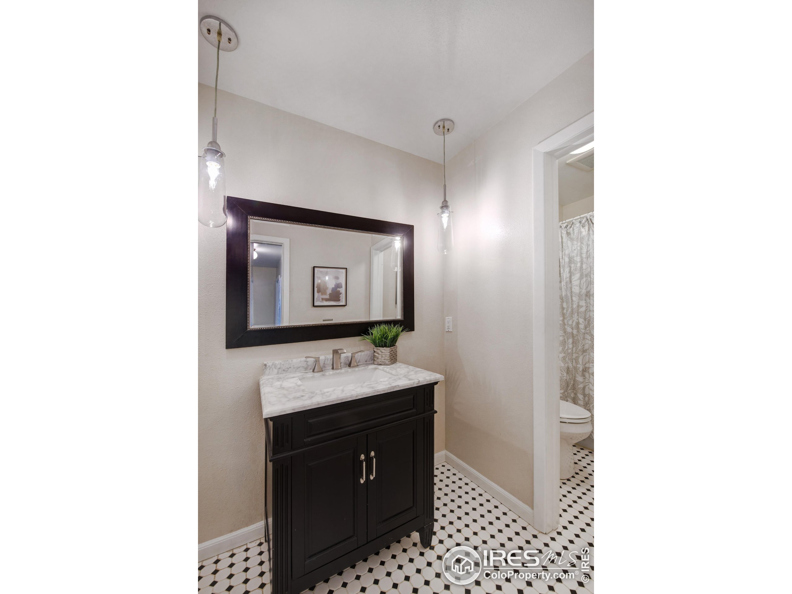 1895 Alpine Avenue, Unit E18 Boulder, CO 80304 - Photo 16 of 26 a bathroom with a sink a mirror and a toilet