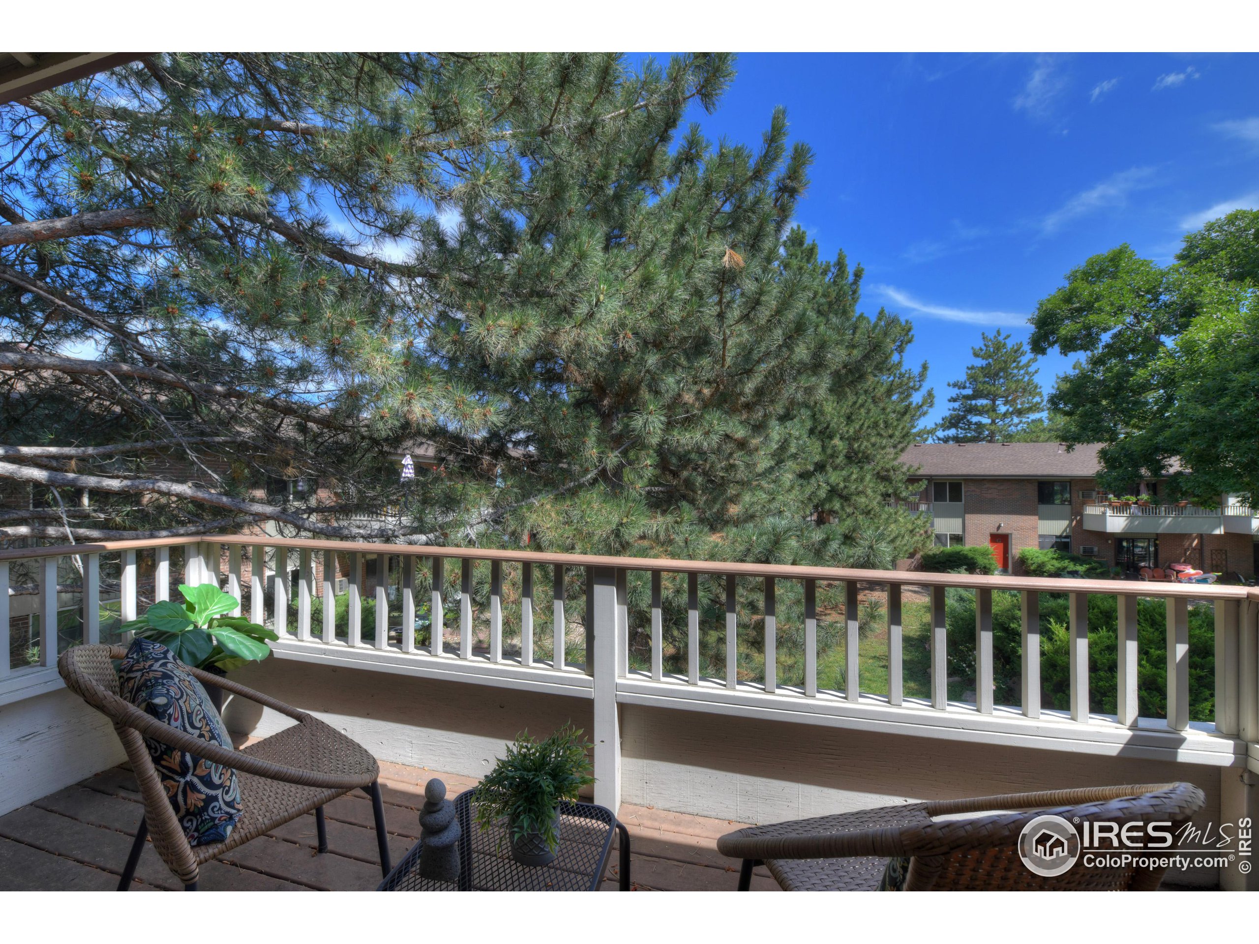 1895 Alpine Avenue, Unit E18 Boulder, CO 80304 - Photo 20 of 26 a view of a wooden chair and table in the back yard of a house