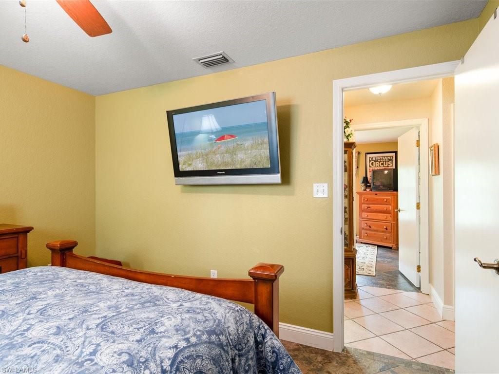 920 10th Street Southeast Naples, FL 34117 - Photo 14 of 16 a bedroom with a bed and a painting on the wall