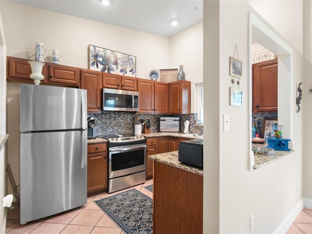 920 10th Street Southeast Naples, FL 34117 - Photo 5 of 16 a kitchen with stainless steel appliances granite countertop a refrigerator a stove and a sink