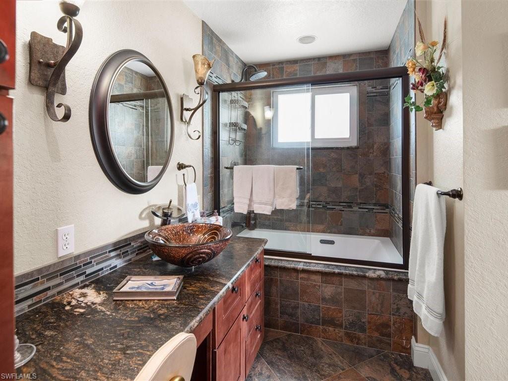 920 10th Street Southeast Naples, FL 34117 - Photo 8 of 16 a bathroom with a granite countertop sink a mirror and shower