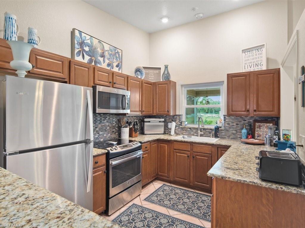 920 10th Street Southeast Naples, FL 34117 - Photo 9 of 16 a kitchen with stainless steel appliances granite countertop a sink stove and refrigerator