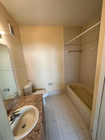 a bathroom with a granite countertop sink a mirror and shower