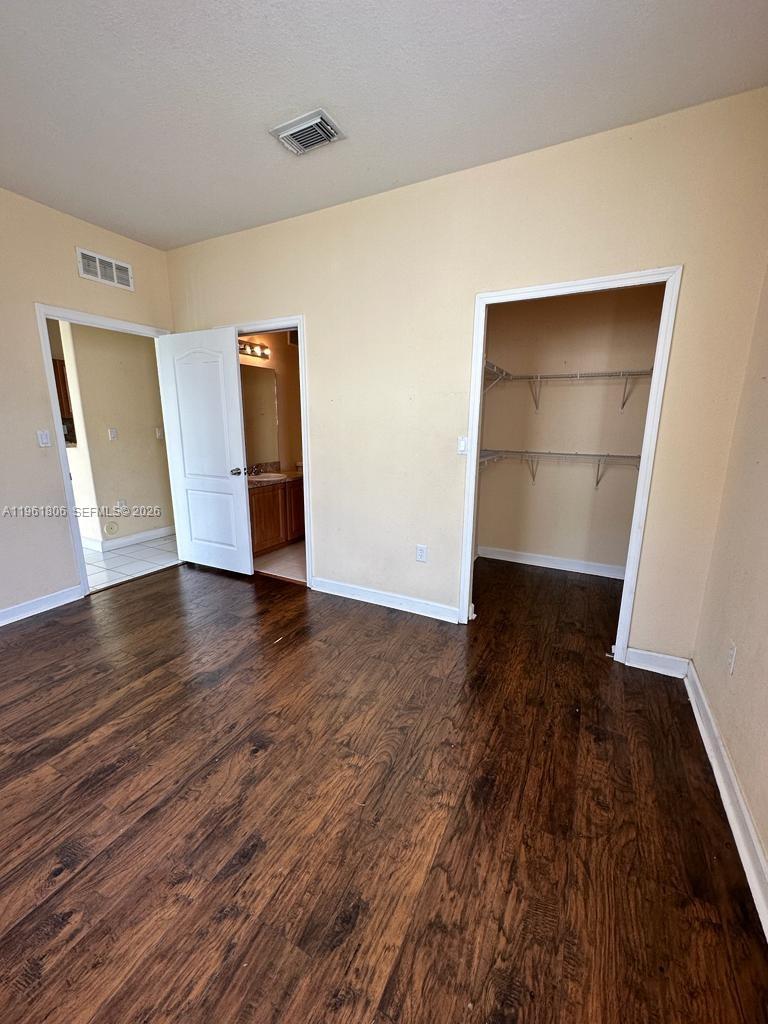 2900 Southeast 17th Avenue, Unit 103 Homestead, FL 33035 - Photo 13 of 16 an empty room with wooden floor and closet