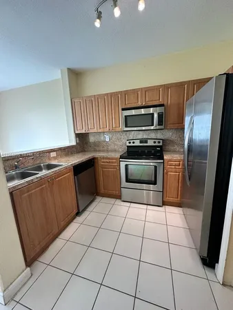 a kitchen with granite countertop a stove top oven and stainless steel appliances