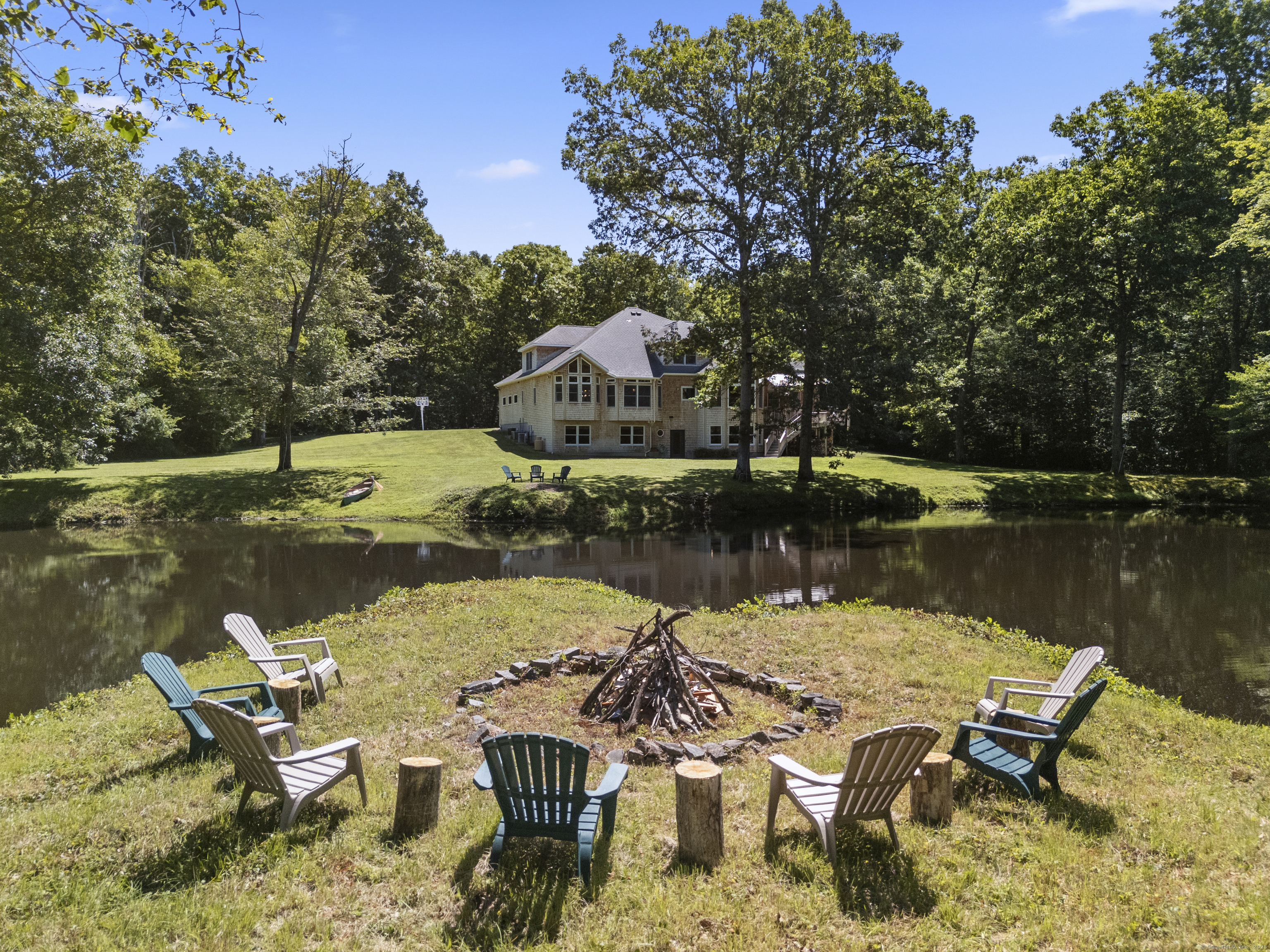 70 Morgan Road Salem, CT 06420 - Photo 32 of 38 a view of a lake with a table and chairs under an umbrella