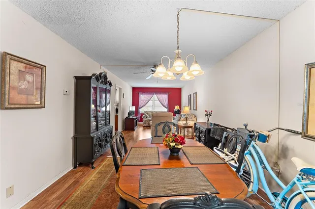 a view of a dining room with furniture a chandelier and wooden floor