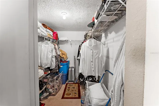a view of walk in closet with clothes