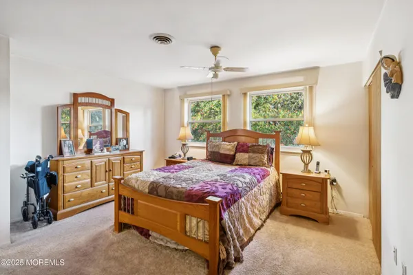 a bedroom with a bed a chandelier and dresser