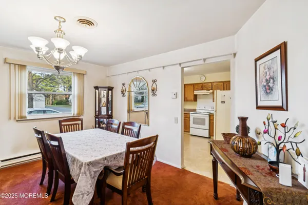 a view of a dining room with furniture and chandelier