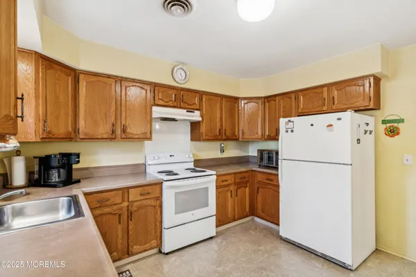 a kitchen with white cabinets and white appliances