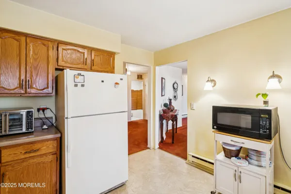 a white refrigerator freezer and a stove sitting inside of a kitchen
