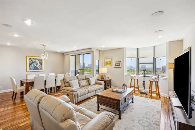 a living room with furniture a flat screen tv and a window